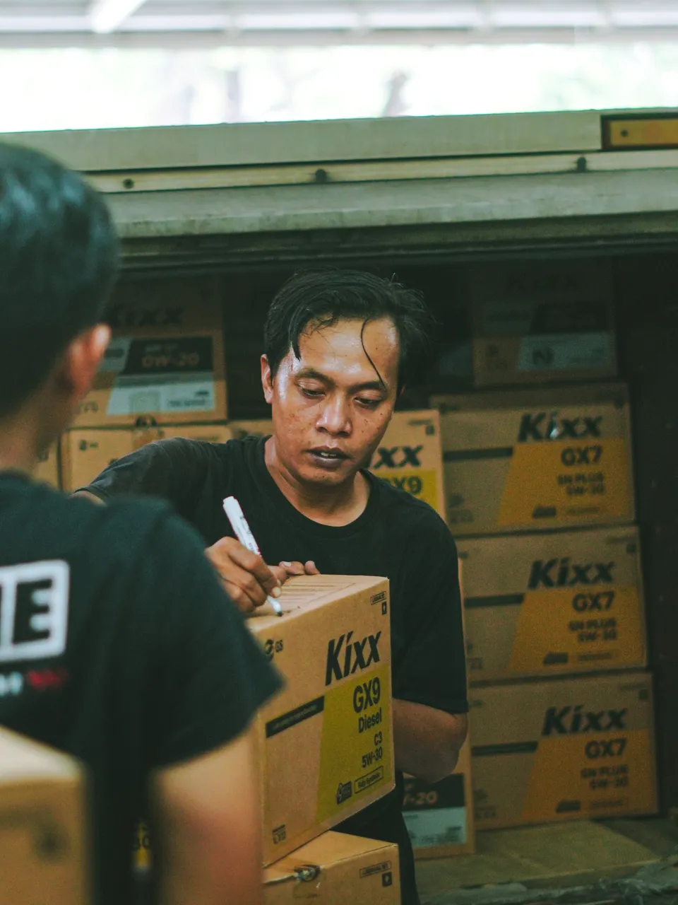 Pekerja menangani kardus di area gudang Jakarta