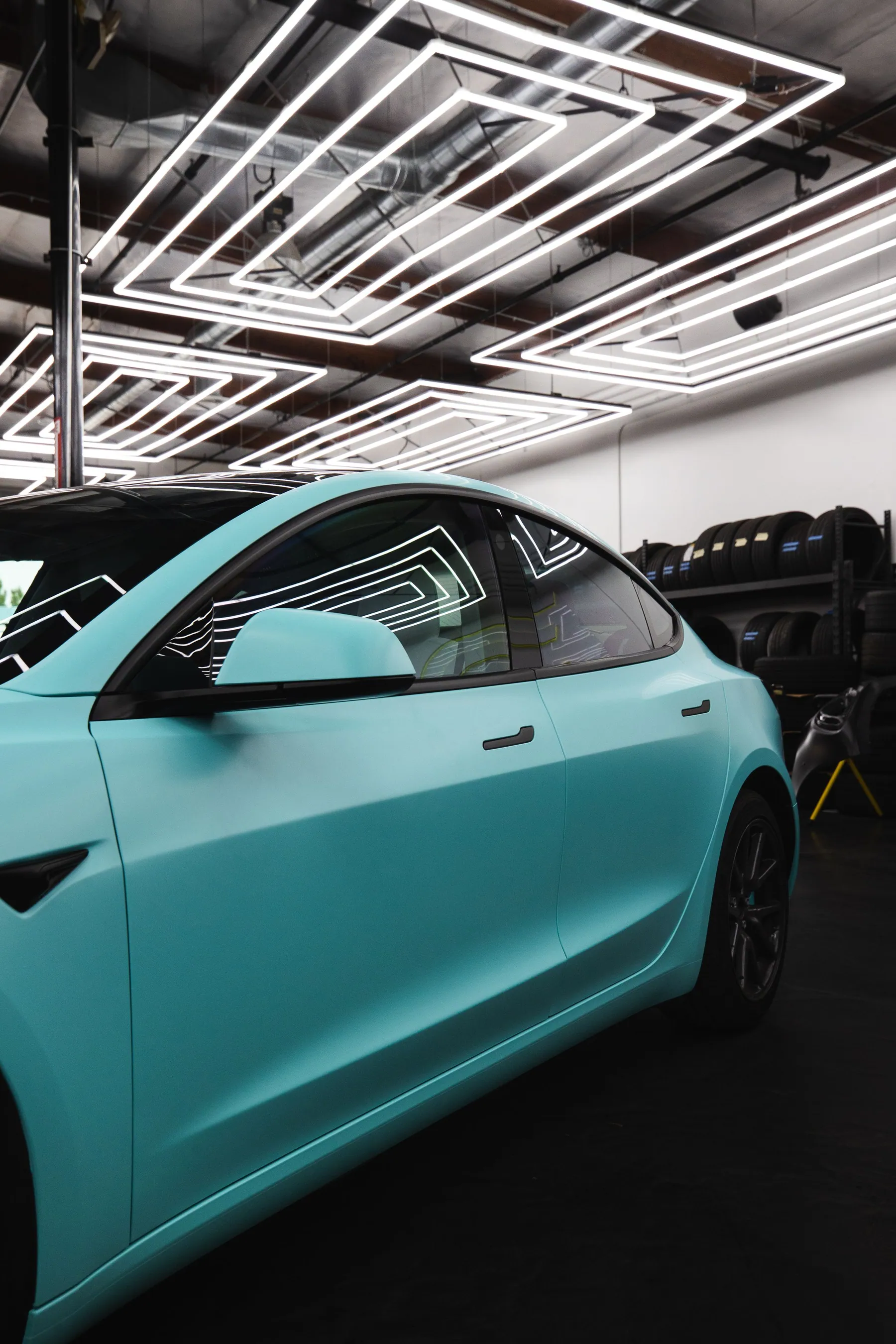 Mobil biru muda matte di studio otomotif