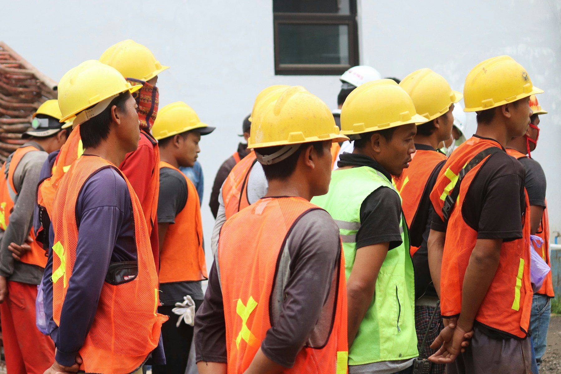 Pekerja proyek konstruksi di Indonesia menggunakan helm keselamatan di area bangunan