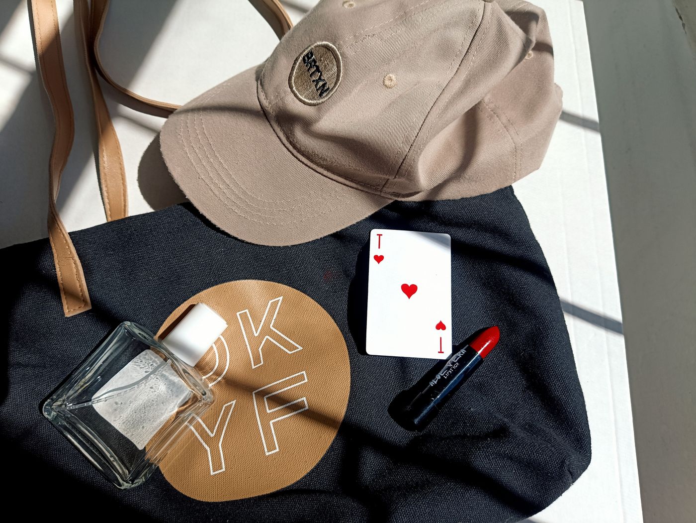 Topi dan tote bag dalam komposisi merchandise