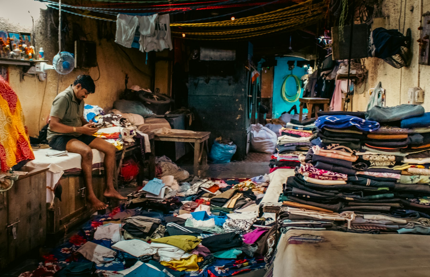 Tim laundry lokal menyortir dan merapikan pakaian pelanggan di area kerja laundry