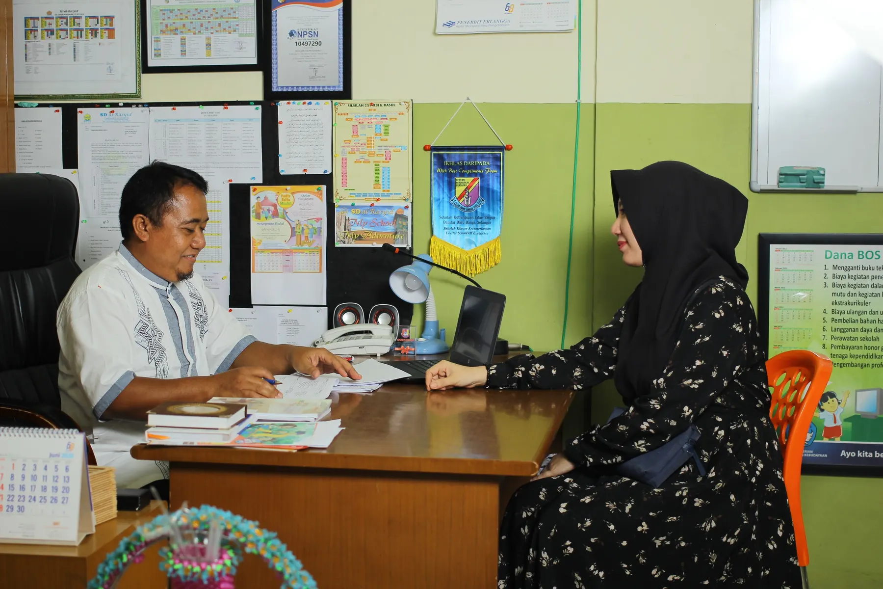 Percakapan administrasi antara dua orang di kantor sekolah Indonesia