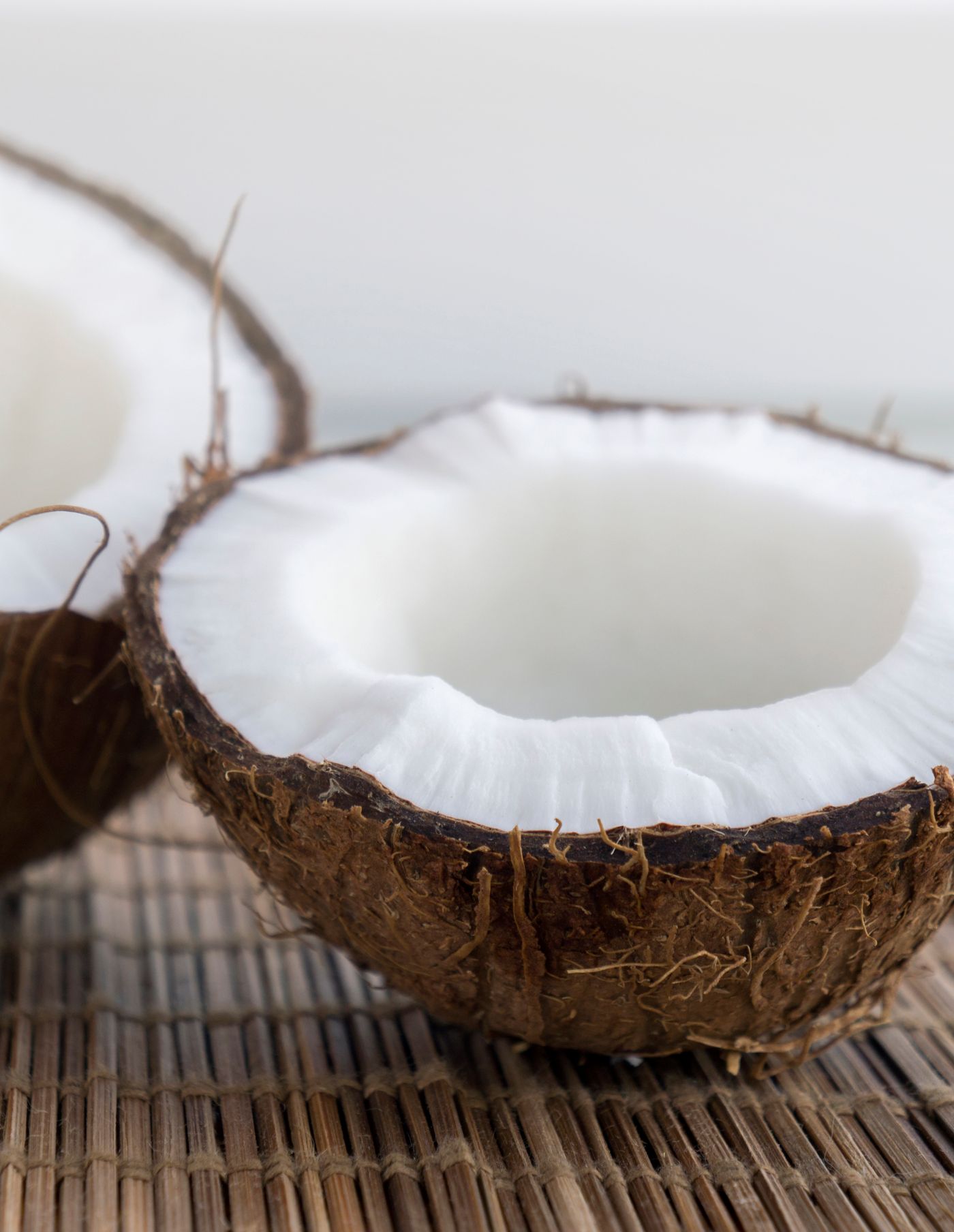Kelapa dibelah di atas anyaman alami