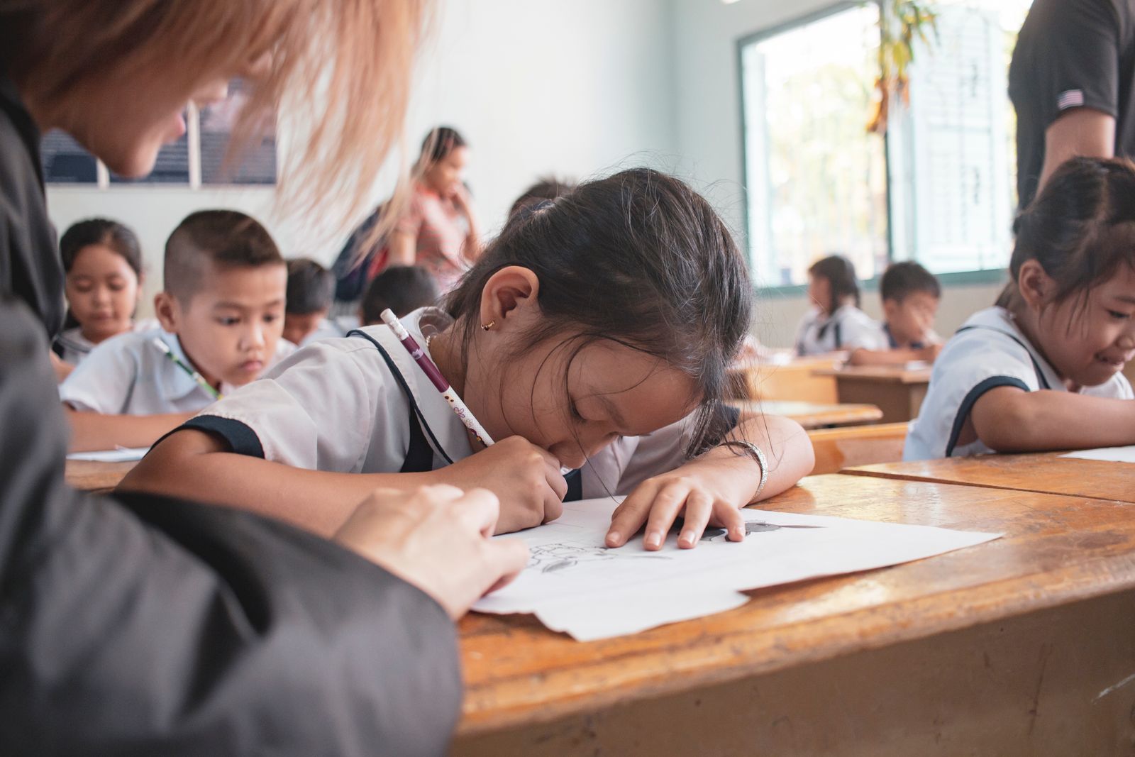 Anak-anak mengerjakan kegiatan menulis di kelas