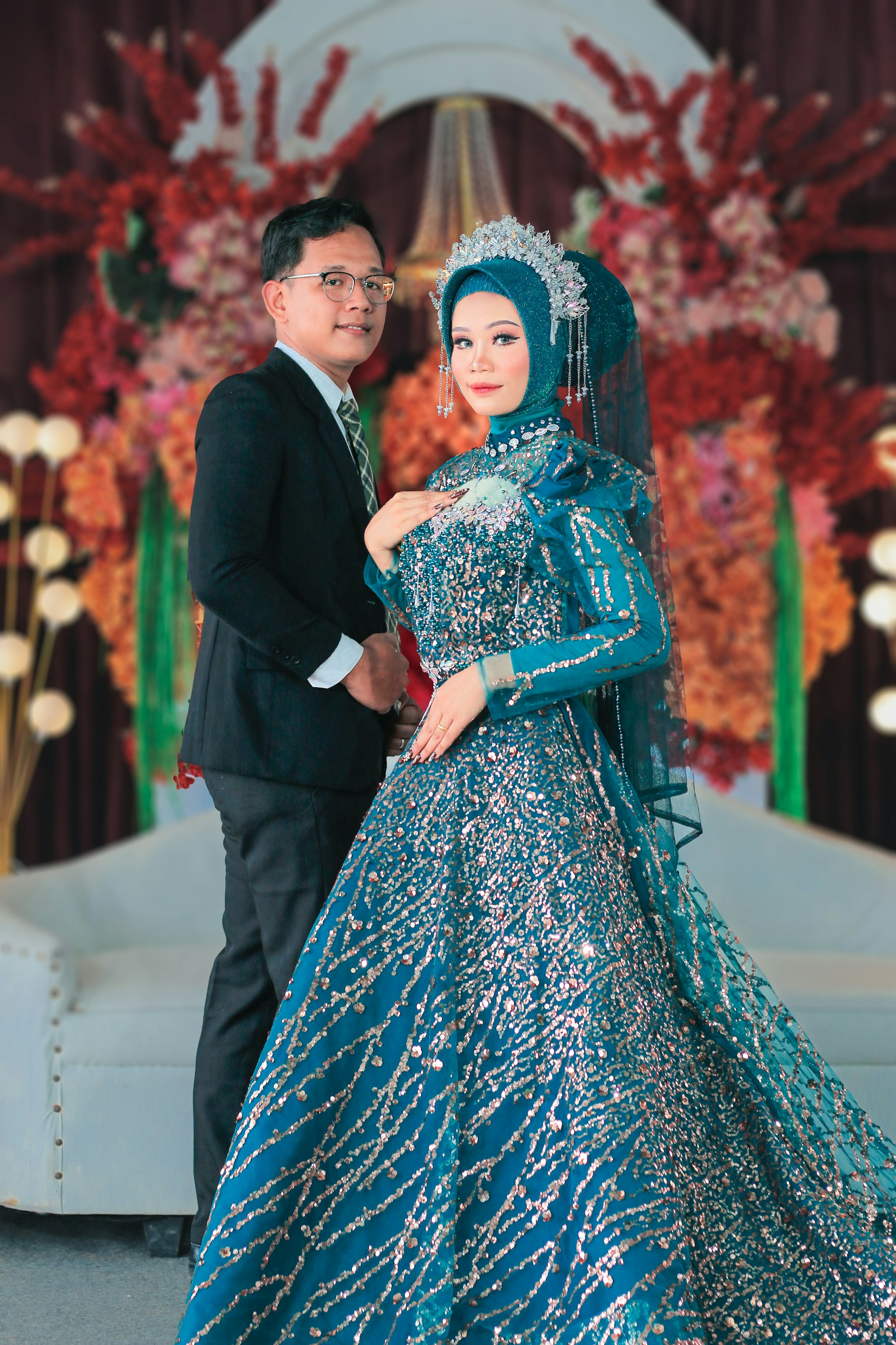 Pasangan pengantin Indonesia dalam busana tradisional pada sesi wedding elegan